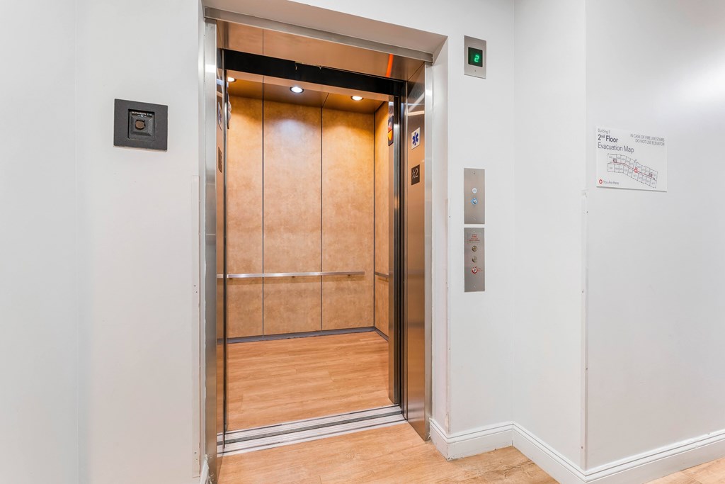 A wooden elevator with a silver exterior and a control panel on the right side.