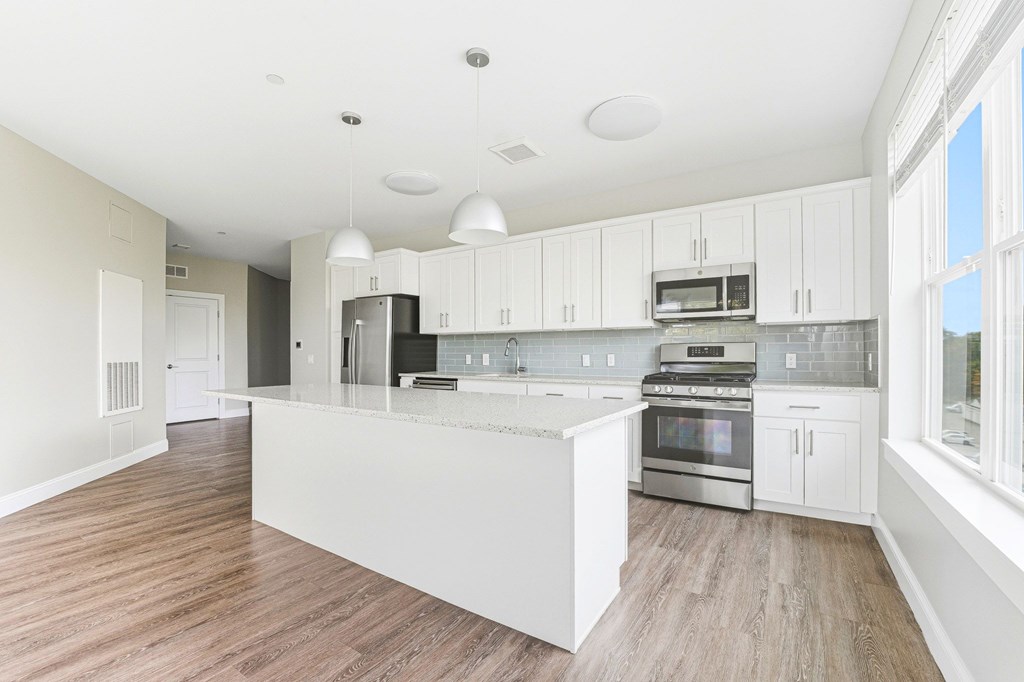 A modern kitchen with white cabinets and stainless steel appliances.