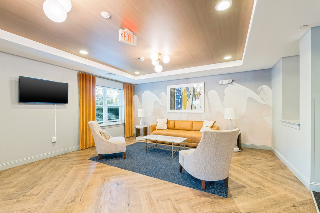 A living room with a couch, chairs, and a television.