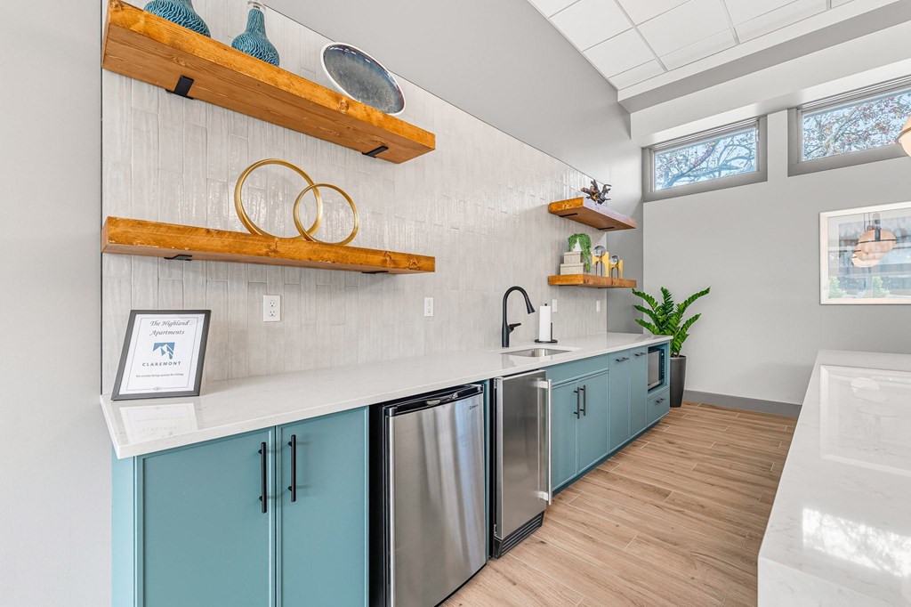 A kitchen with blue cabinets and wooden shelves.