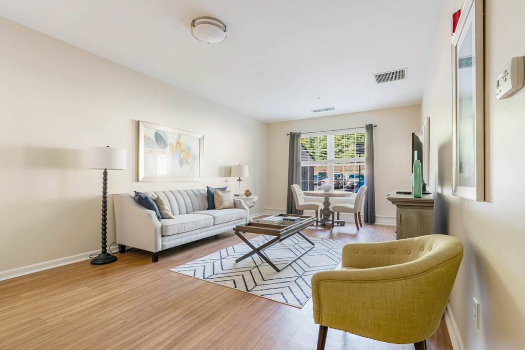 A living room with a white couch and a yellow chair.