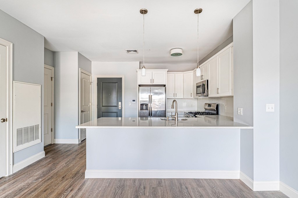 A kitchen with a white island and stainless steel appliances.
