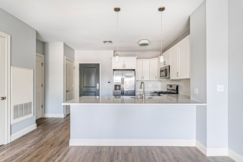 A kitchen with a white island and stainless steel appliances.