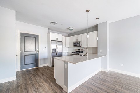 A kitchen with a refrigerator, oven, and cabinets.