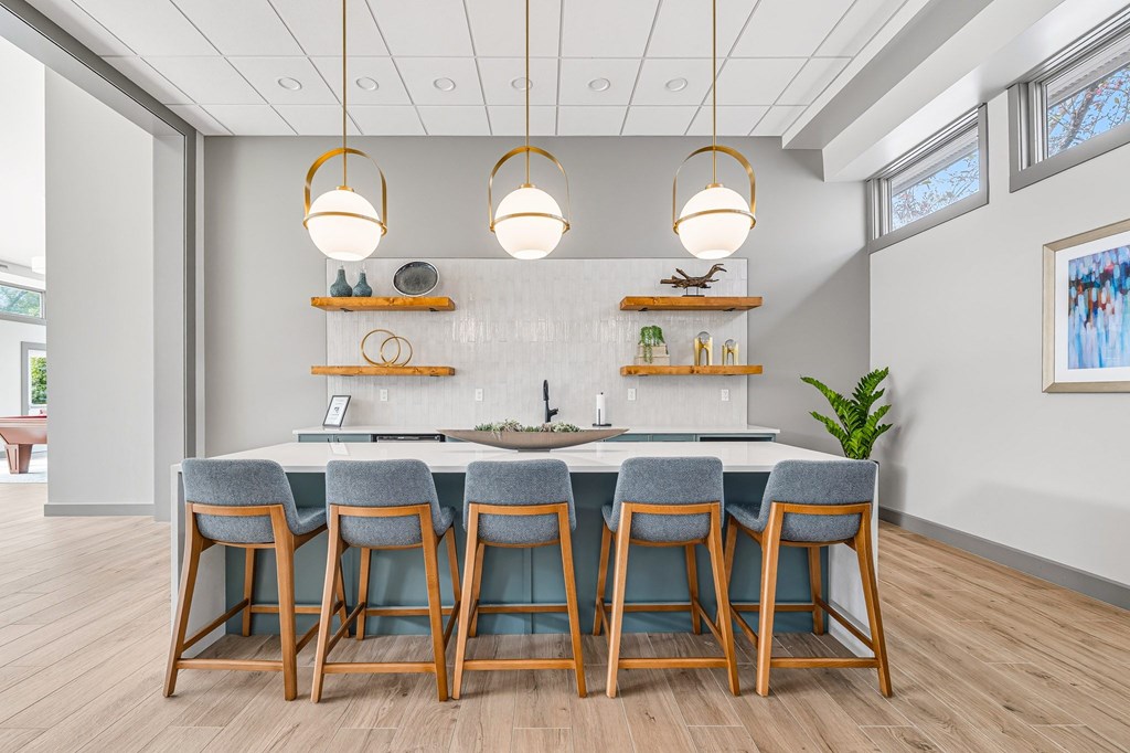 A kitchen with a bar area and chairs.