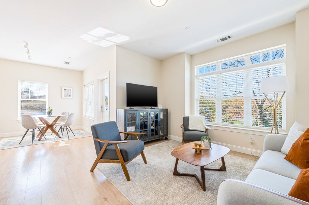 A living room with a television, two chairs, and a coffee table.