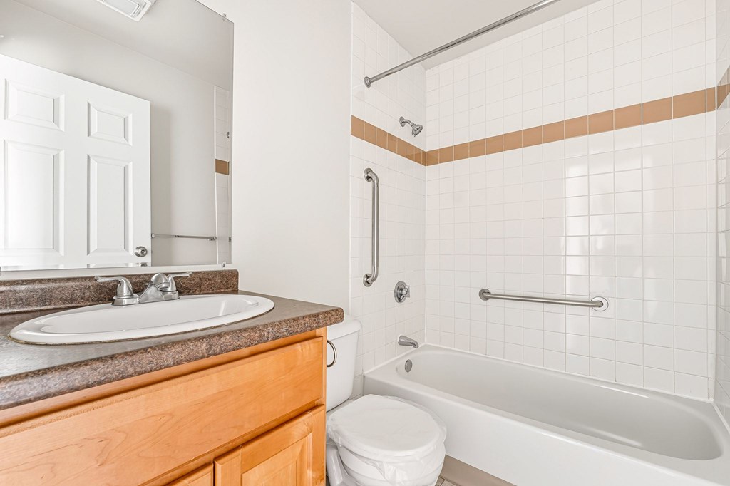 A white toilet sits next to a white sink in a bathroom.