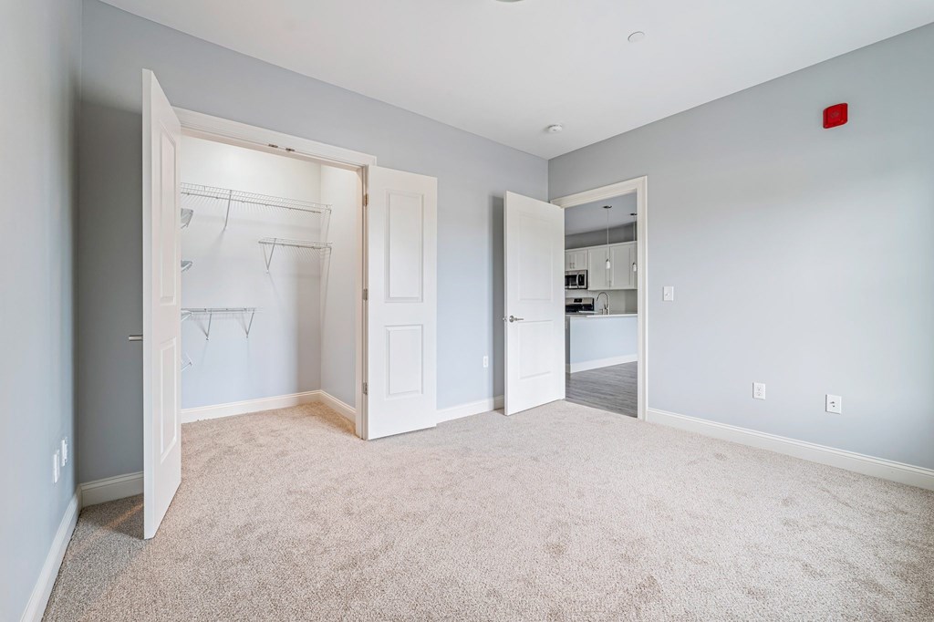 A room with a carpeted floor and a white door.