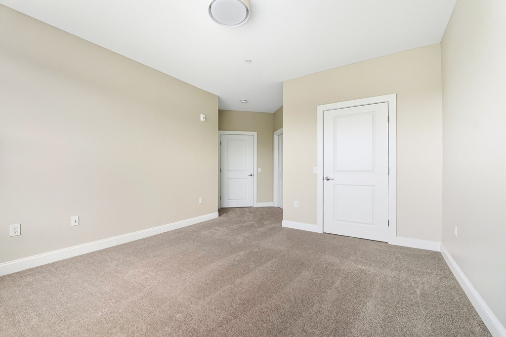 A room with two doors and a carpeted floor.