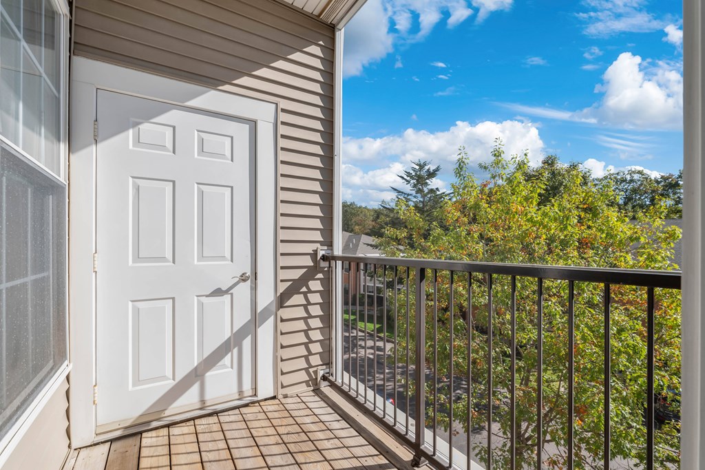A balcony with a white door and a metal railing.
