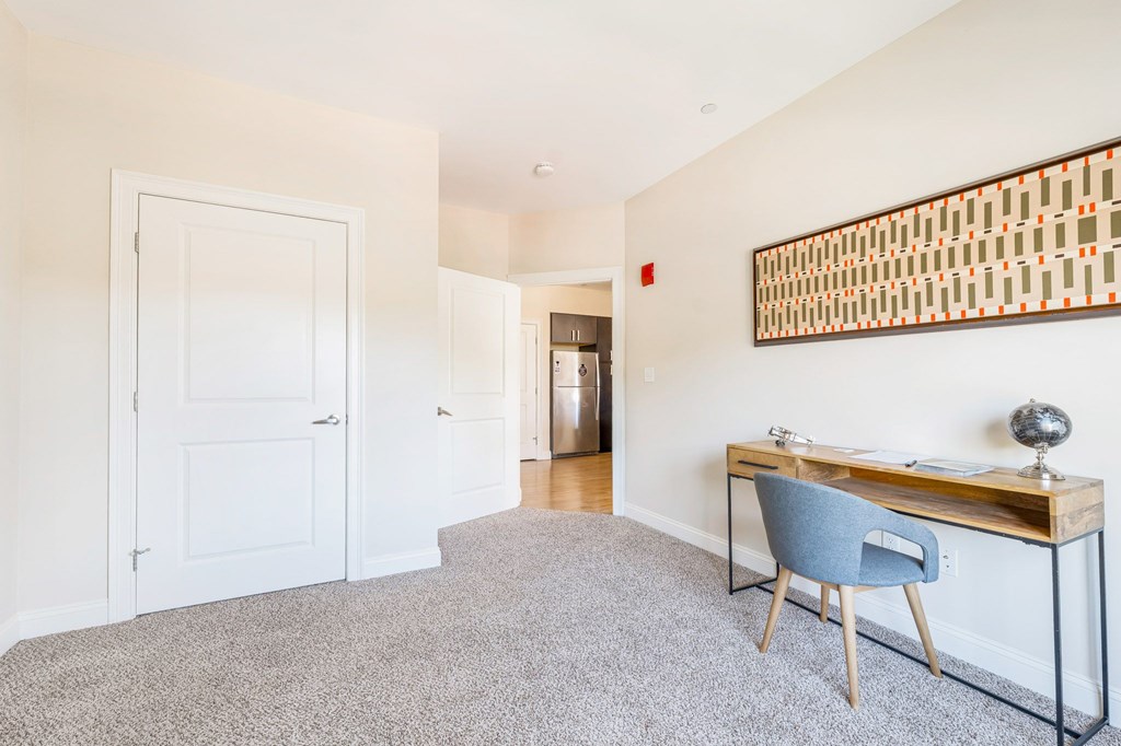 A room with a desk and chair in it.