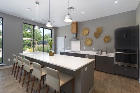 a kitchen with a large island and chairs in front of a window
