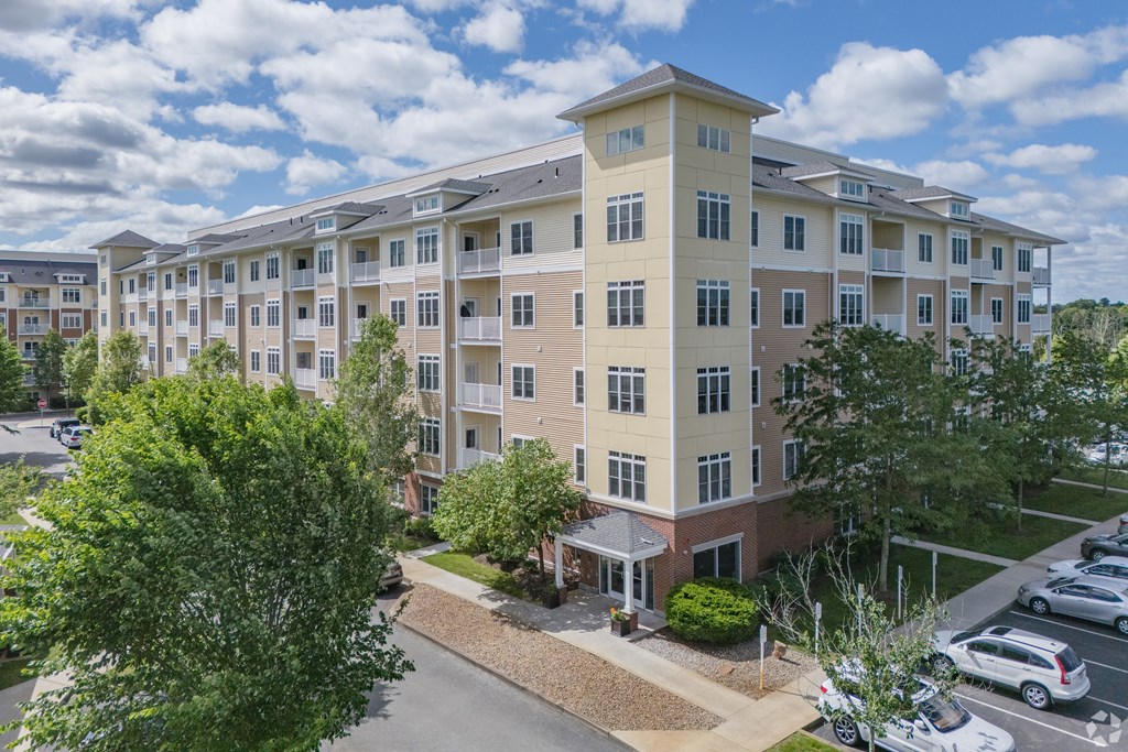 A large apartment complex with a parking lot in front at Axis at Lakeshore Apartments, Massachusetts, 02324
