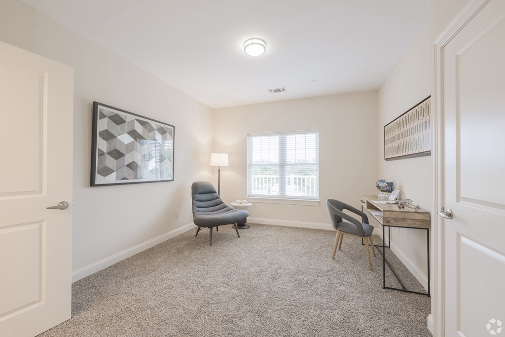 A room with a grey carpet and a chair at Axis at Lakeshore Apartments, Bridgewater, Massachusetts, 02324