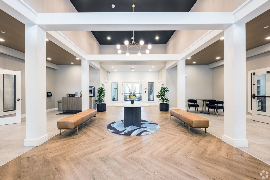 A spacious lobby with a wooden floor and white columns at Axis at Lakeshore Apartments, Bridgewater, Massachusetts, 02324