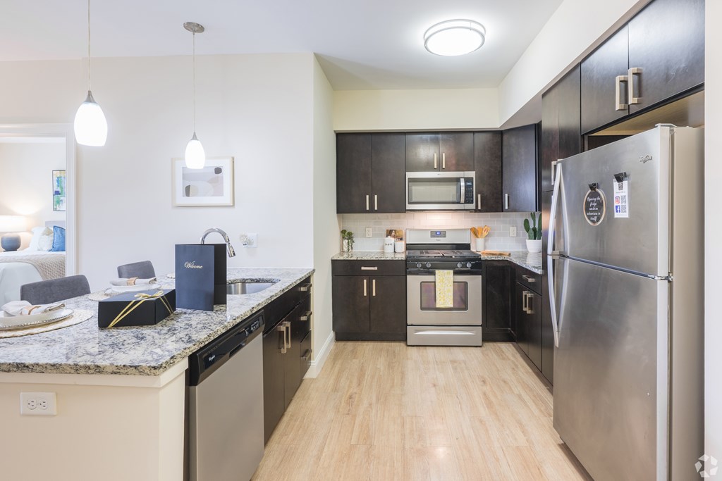 A kitchen with a refrigerator, oven, and microwave at Axis at Lakeshore Apartments, Bridgewater, 02324