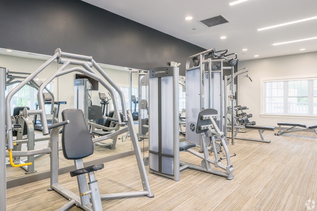 A gym with a variety of equipment including a leg press machine at Axis at Lakeshore Apartments, Bridgewater, MA