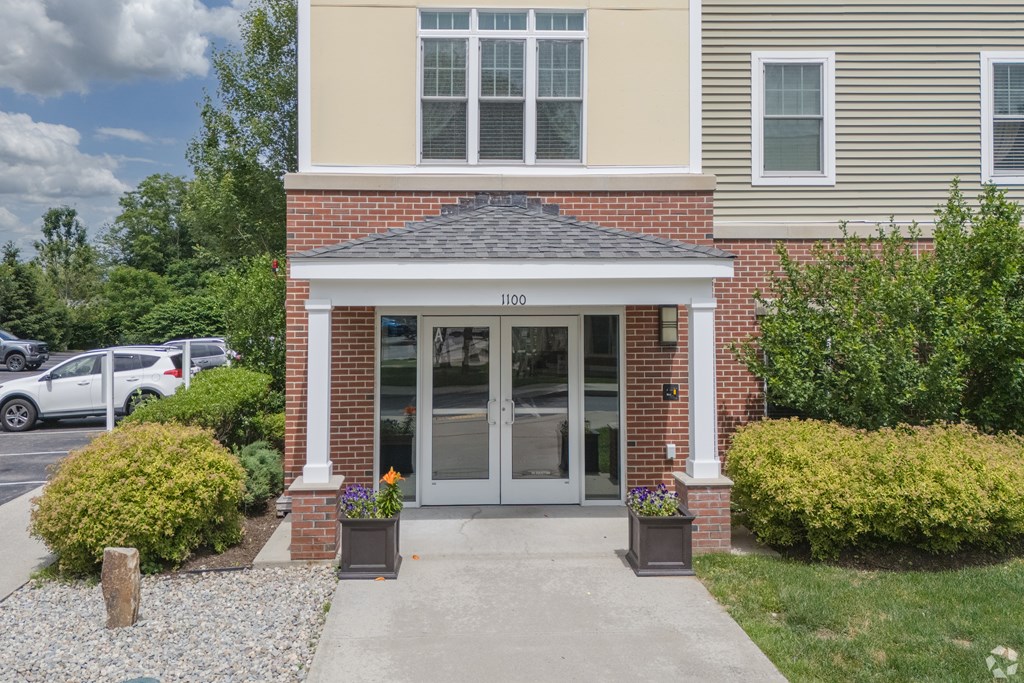 A house with a grey front door and a small porch at Axis at Lakeshore Apartments, Bridgewater, Massachusetts, 02324