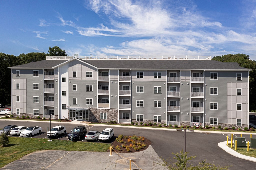 an image of an apartment building with cars parked in front of it