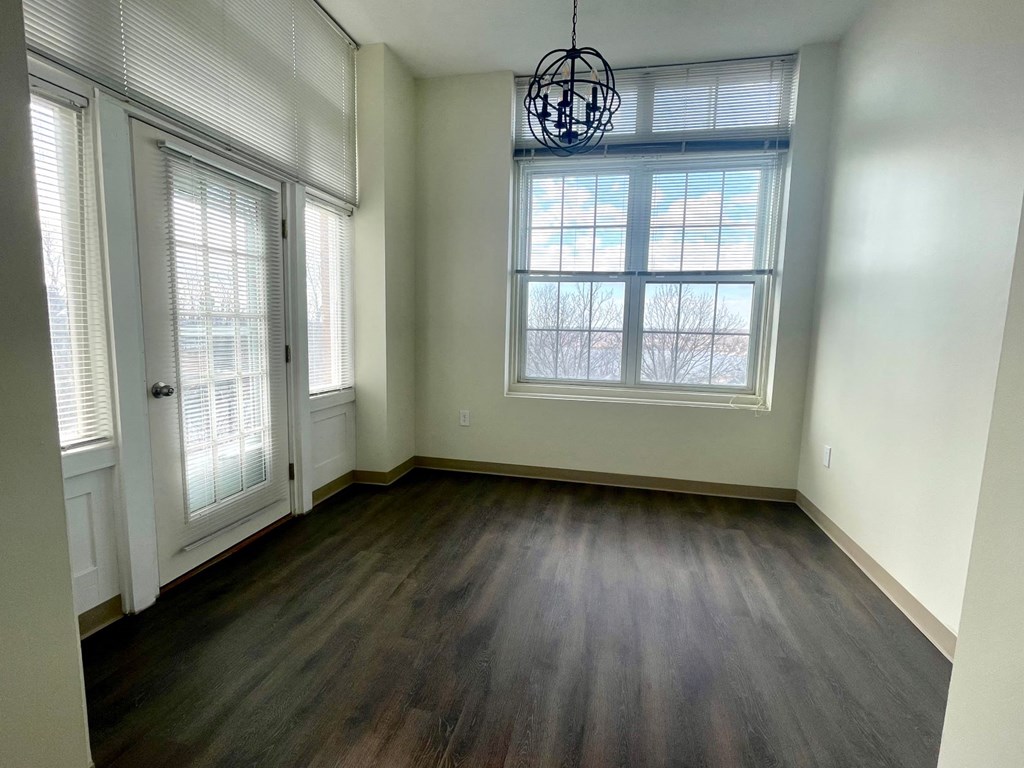 A room with a large window and a wooden floor.