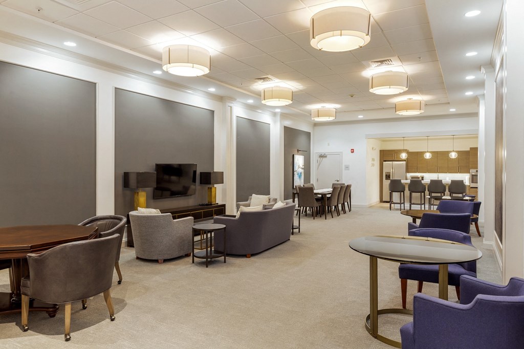 a large lounge area with chairs and tables and a television