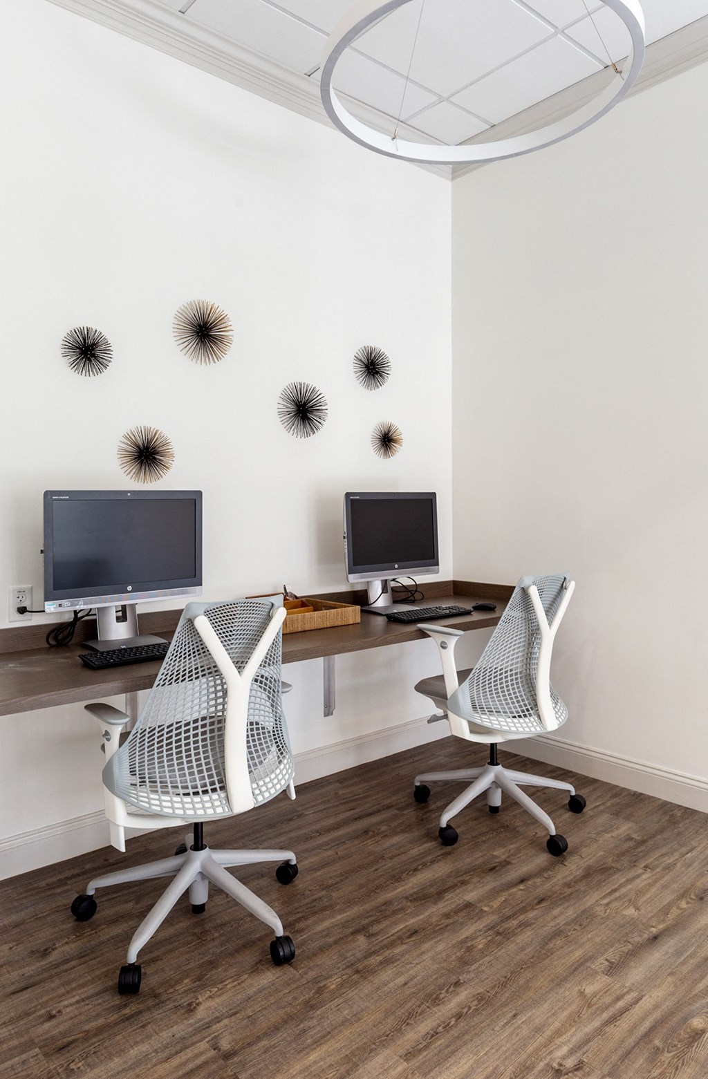 two chairs and two monitors on a desk in a room