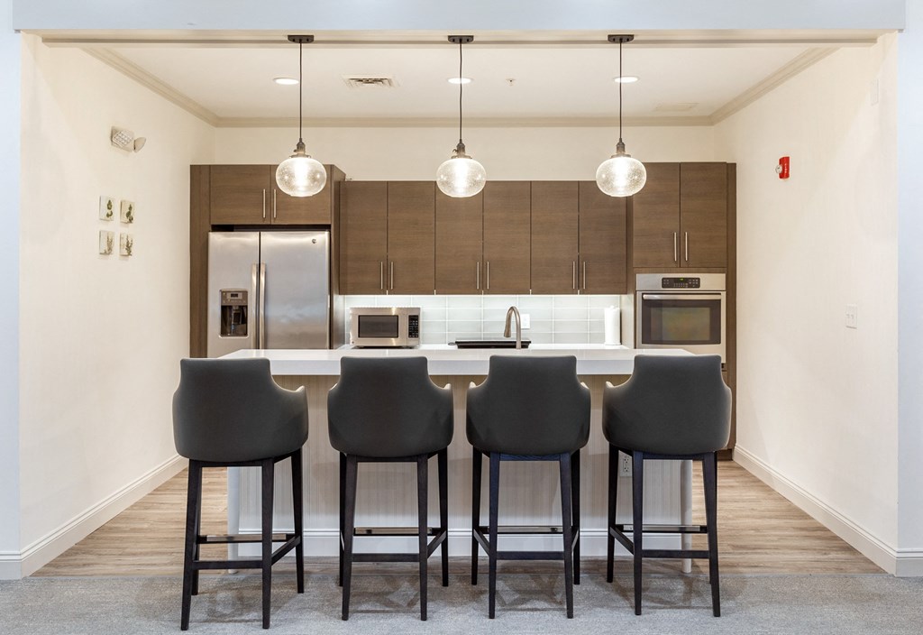 a kitchen with bar stools in front of a kitchen counter with