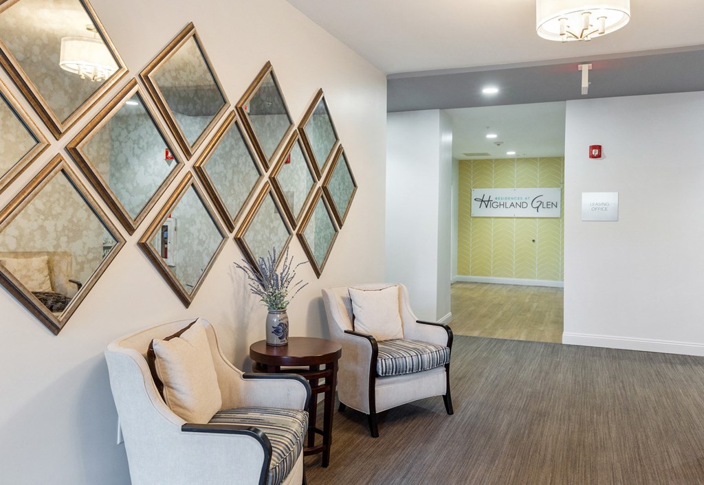 a living room with chairs and paintings on the wall