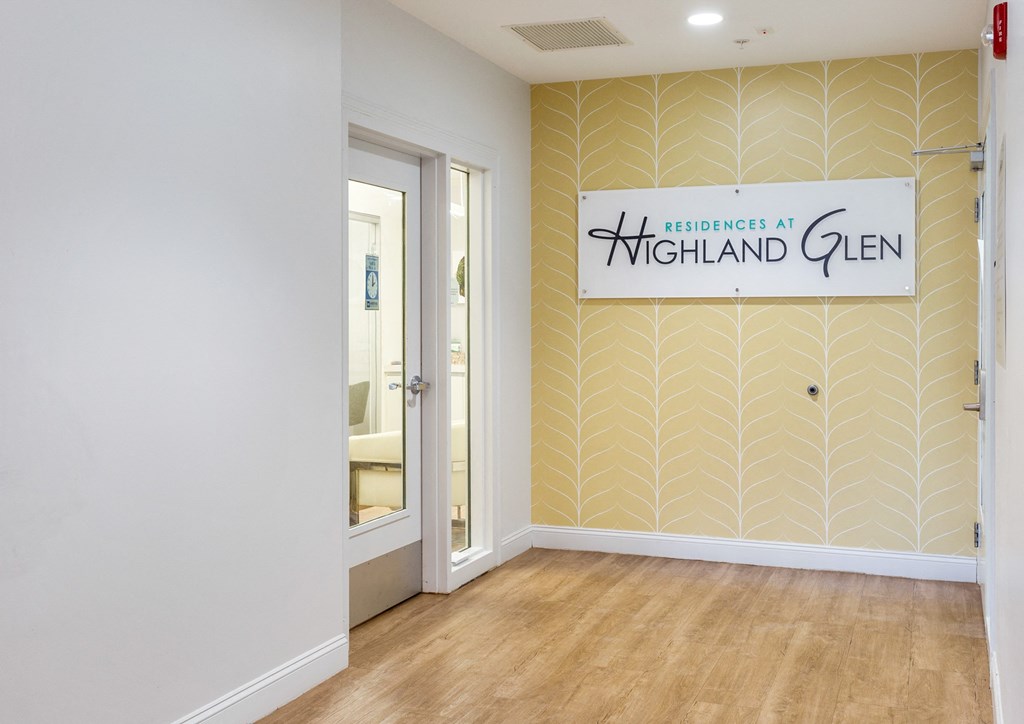 a hallway with a sign on the wall and a door to a bathroom