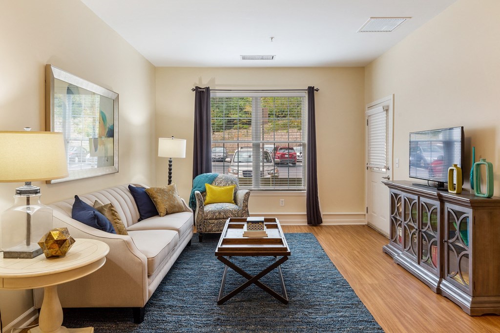 a living room with a couch and a tv and a window