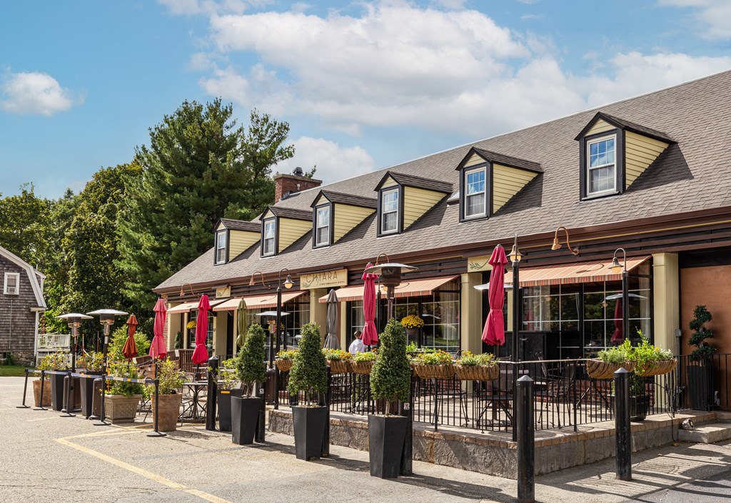 a row of restaurants with red umbrellas in front of a building