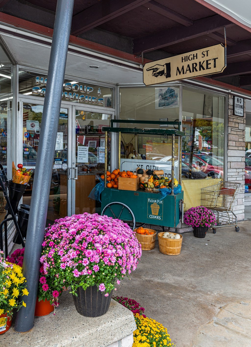 a fruit stand with flowers outside of a market