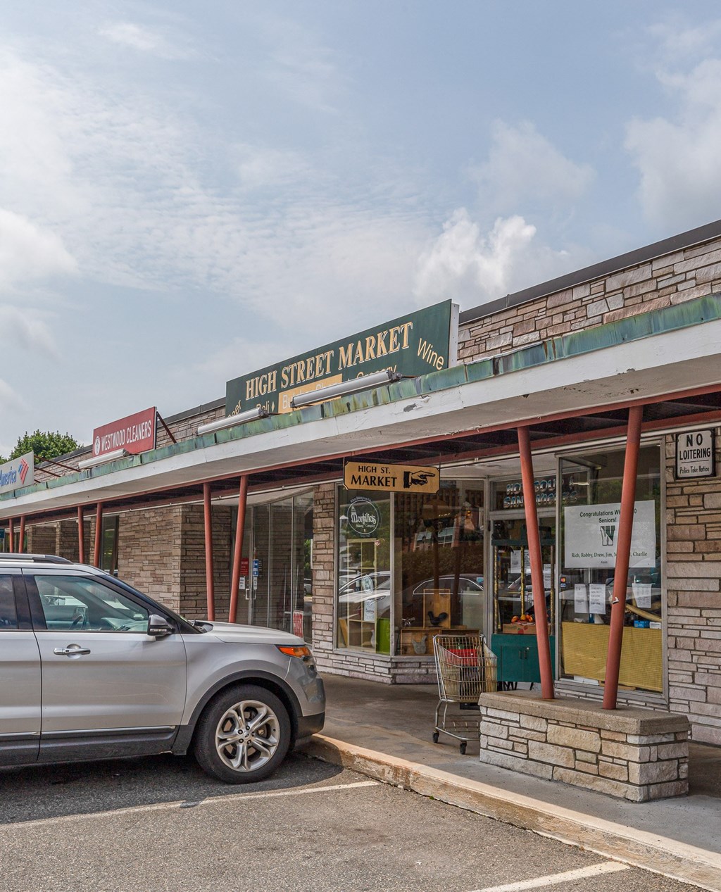 the front of high street market with a car parked outside