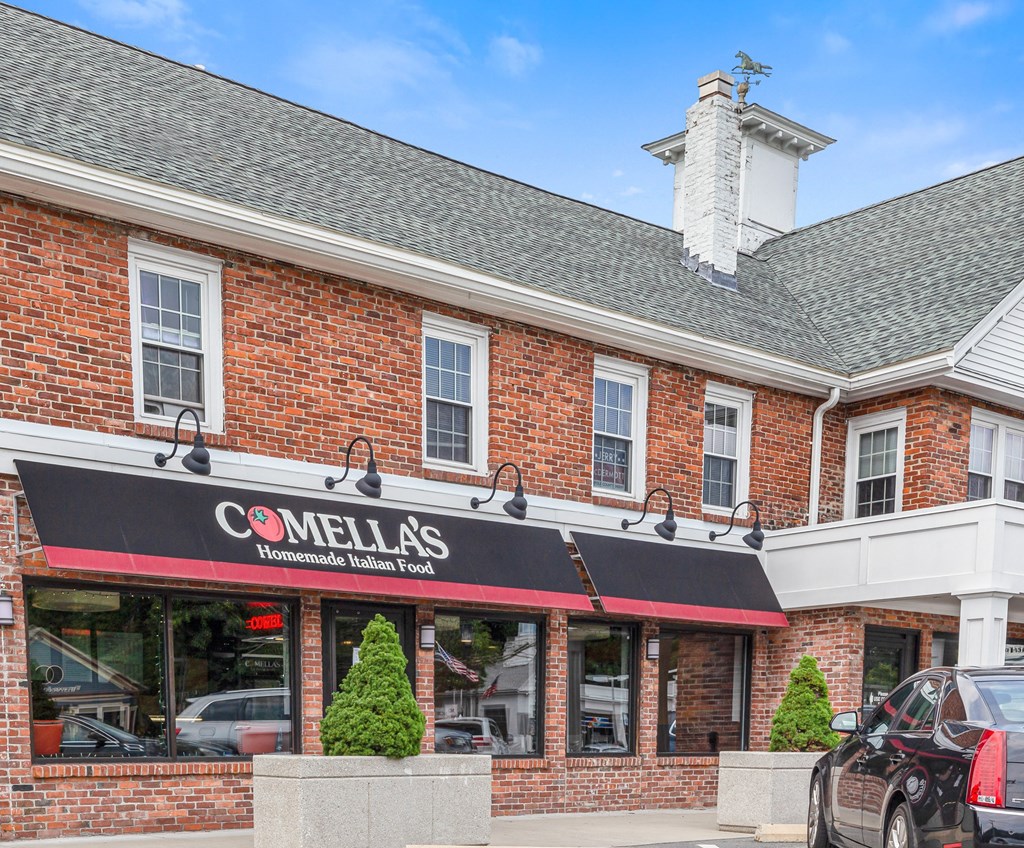 the front of a red brick building with a black and red sign