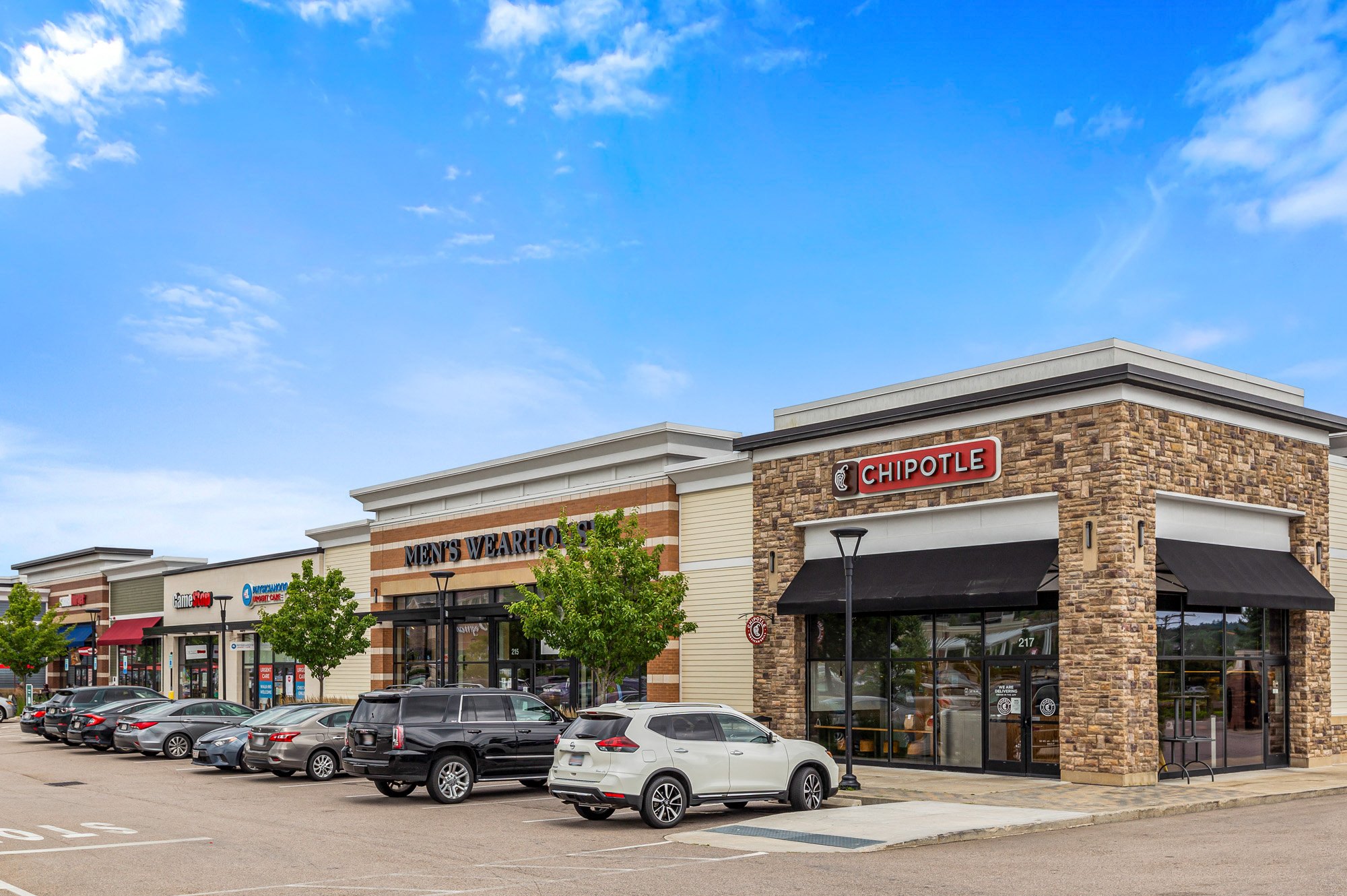a shopping center with cars parked in front of it