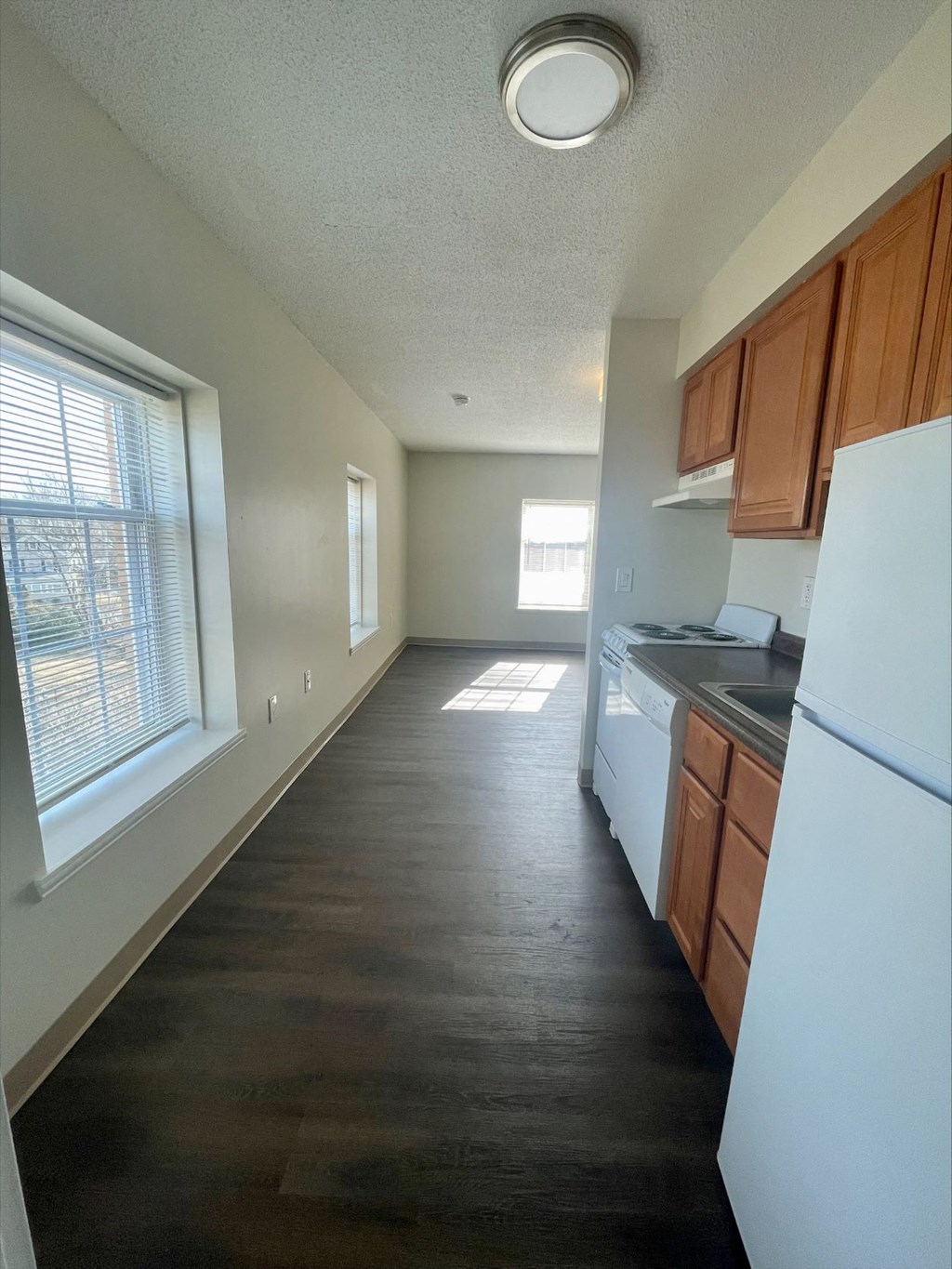 A kitchen with white appliances and wooden cabinets.