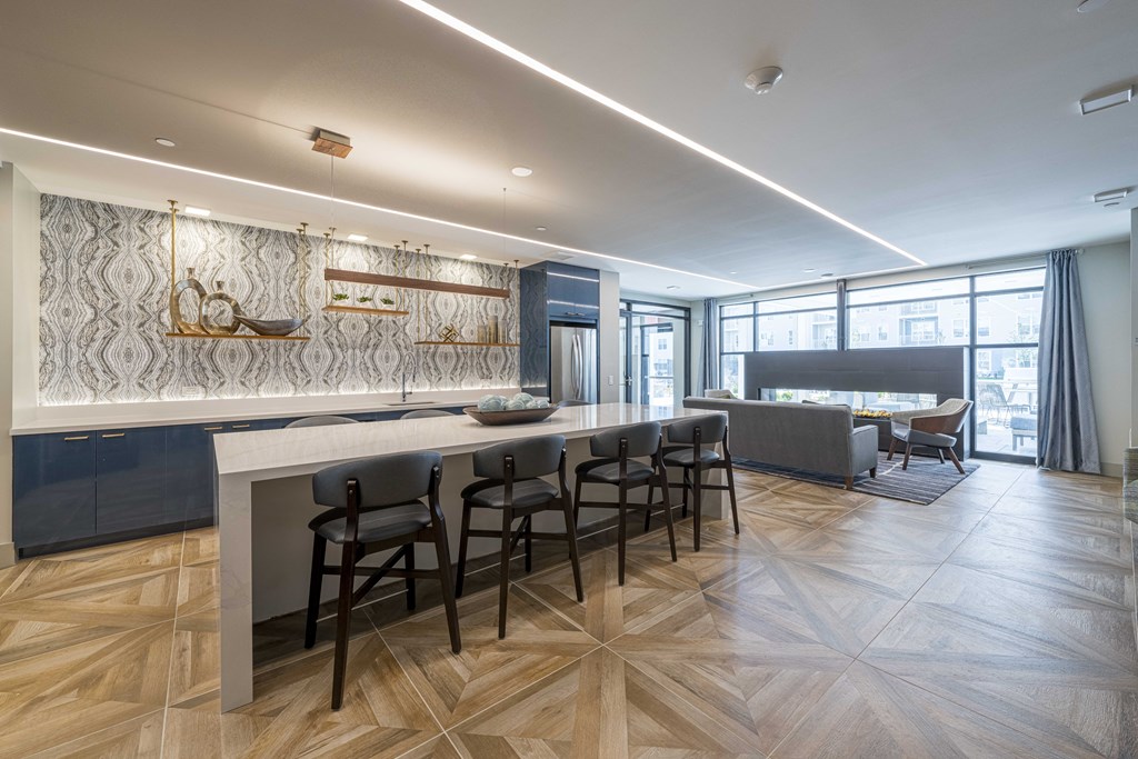 a kitchen and living room with a bar and chairs and a table