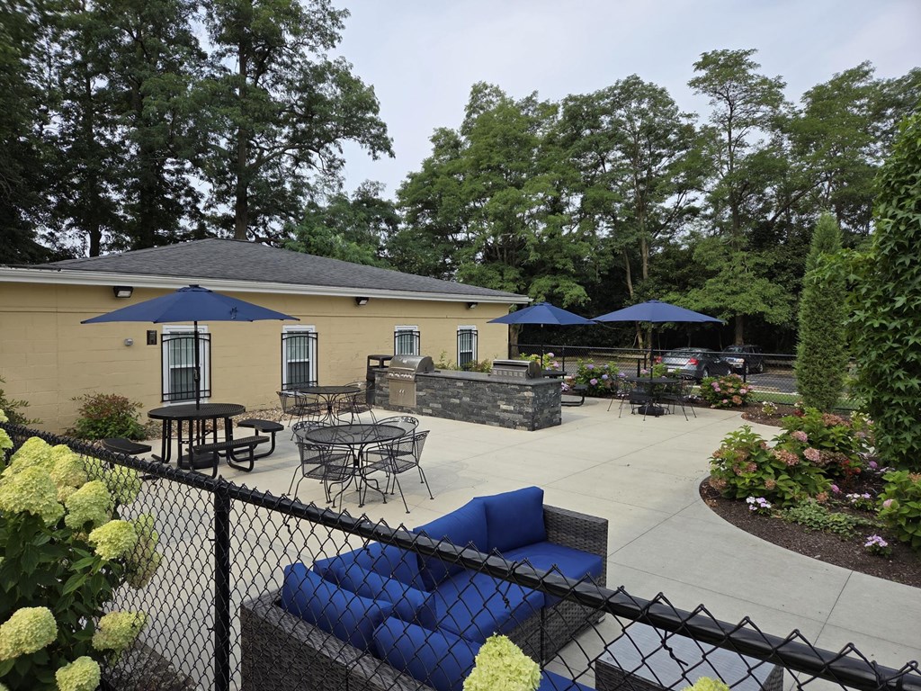 A patio area with tables and chairs and umbrellas.