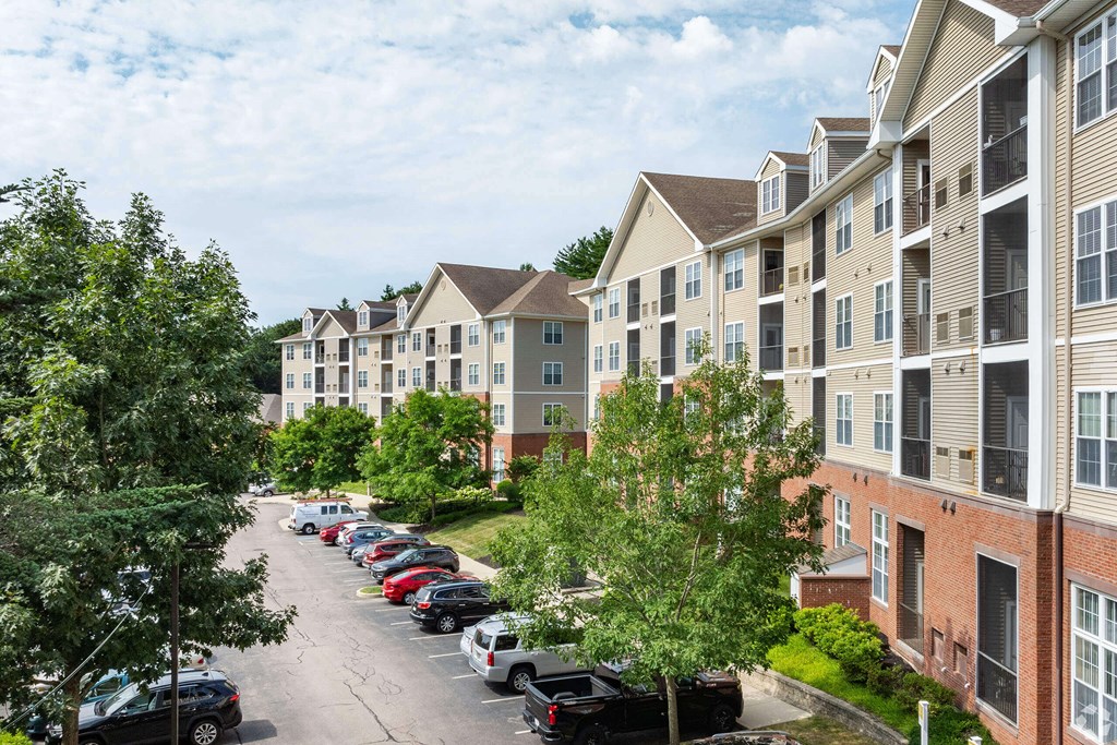 an aerial view of an apartment complex with cars parked on the street