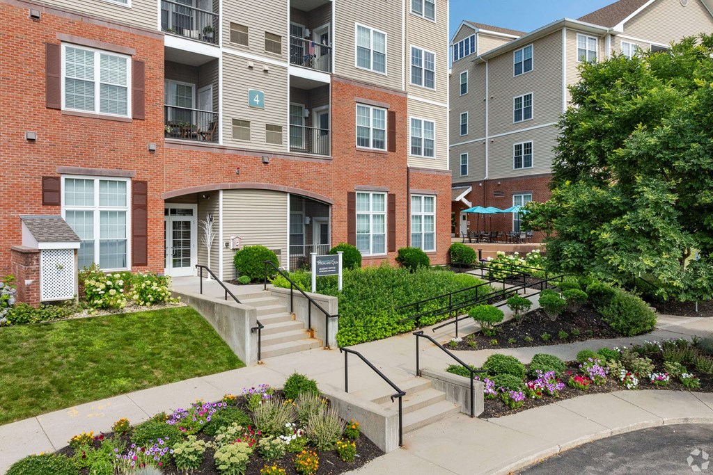 an exterior view of an apartment building with stairs and gardens