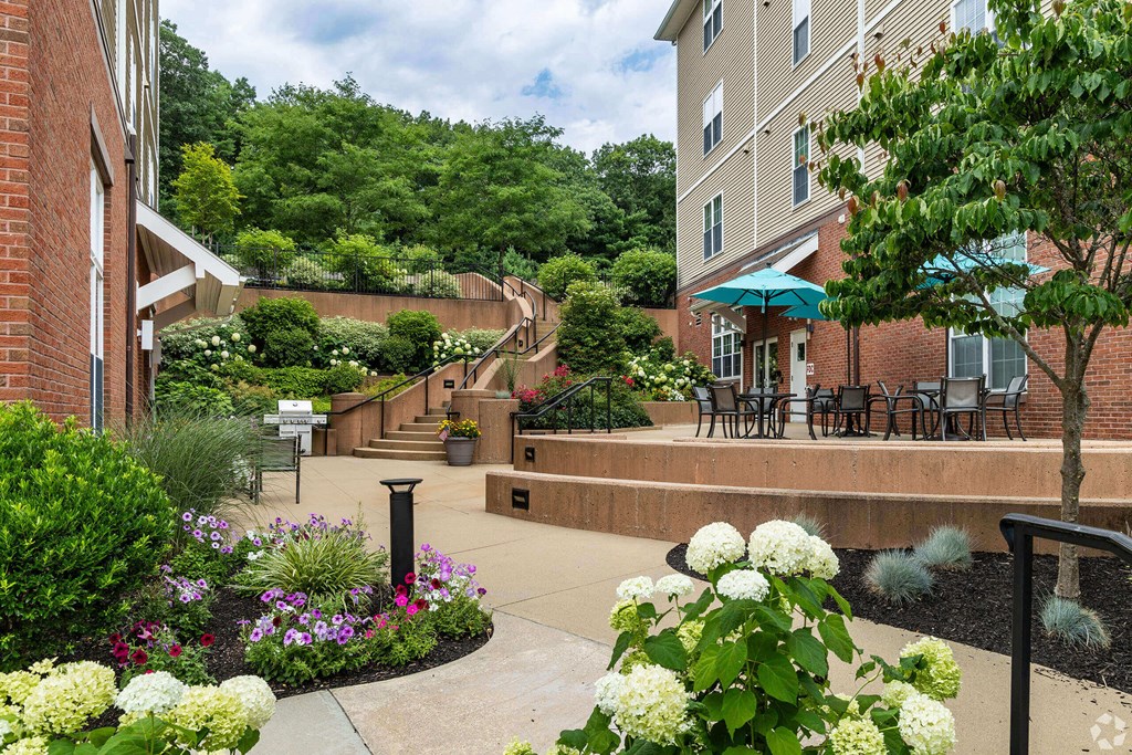 a courtyard with flowers and tables outside of a building