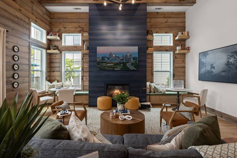 A living room with a fireplace and a painting of a cityscape on the wall.