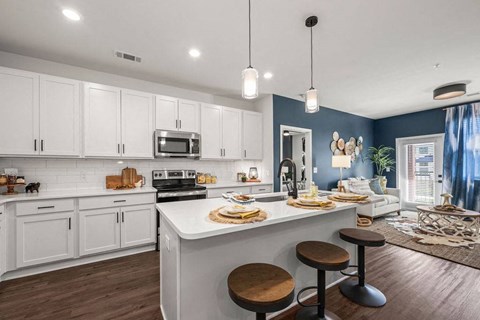 A kitchen with white cabinets and a blue wall.