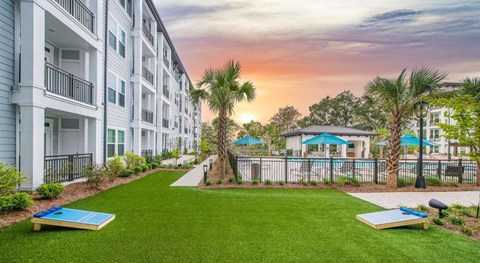 A sunset view of a residential area with apartment buildings and a pool.