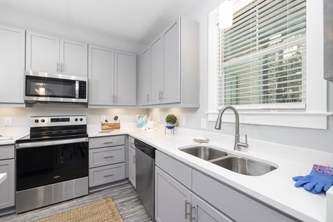 A kitchen with white cabinets and a black oven.