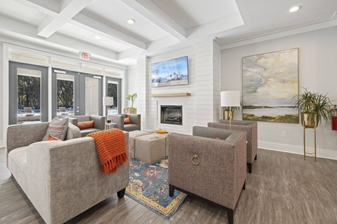 A living room with a grey couch and a fireplace.