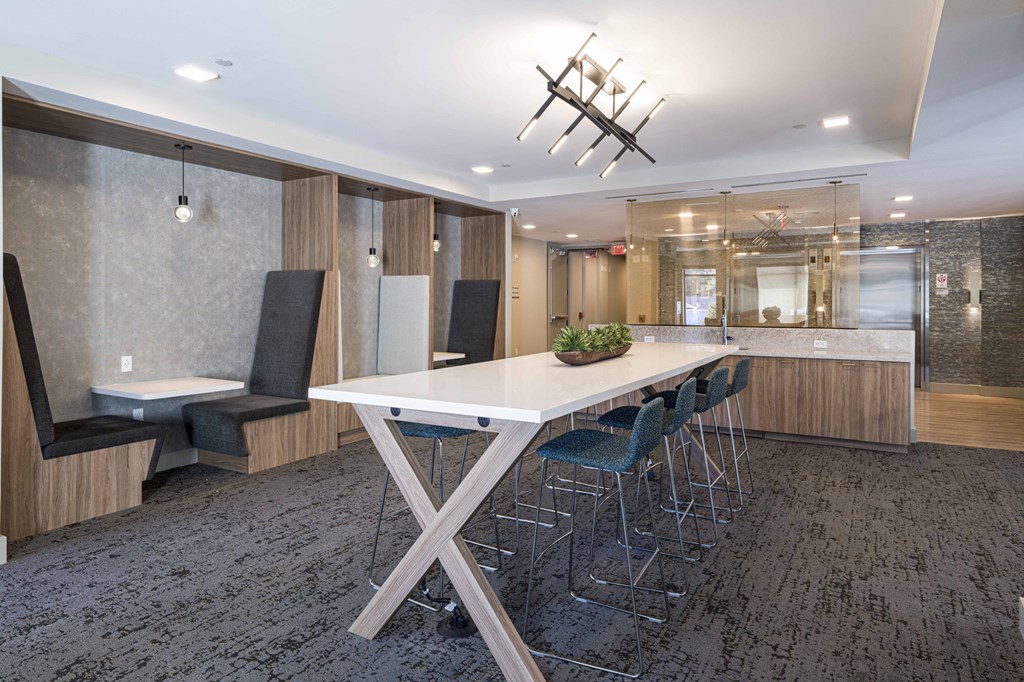 a kitchen with a long white table and chairs