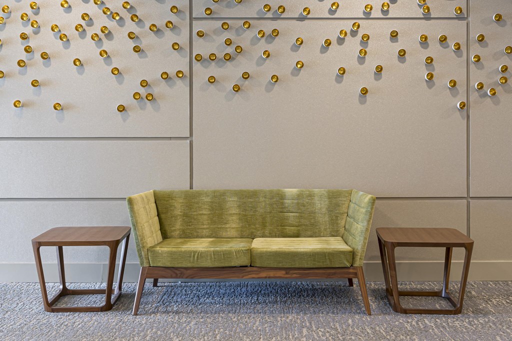 a couch and tables in front of a wall with flowers