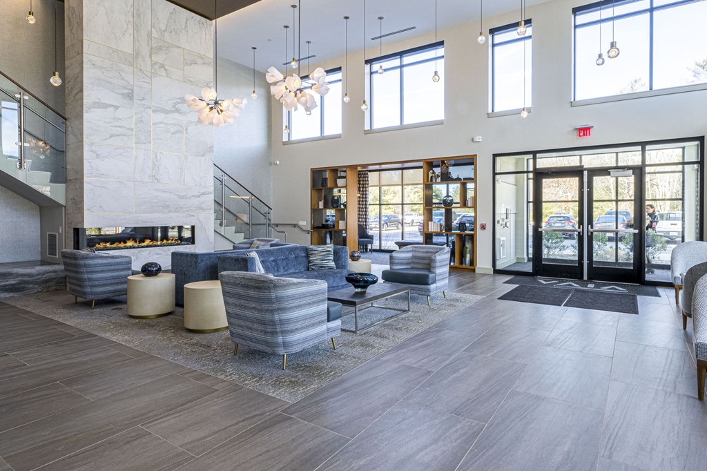 a lobby with couches and chairs and glass doors