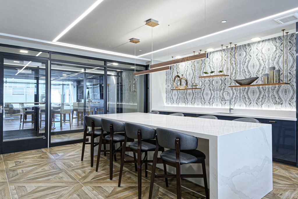 a kitchen with a marble counter top and black chairs